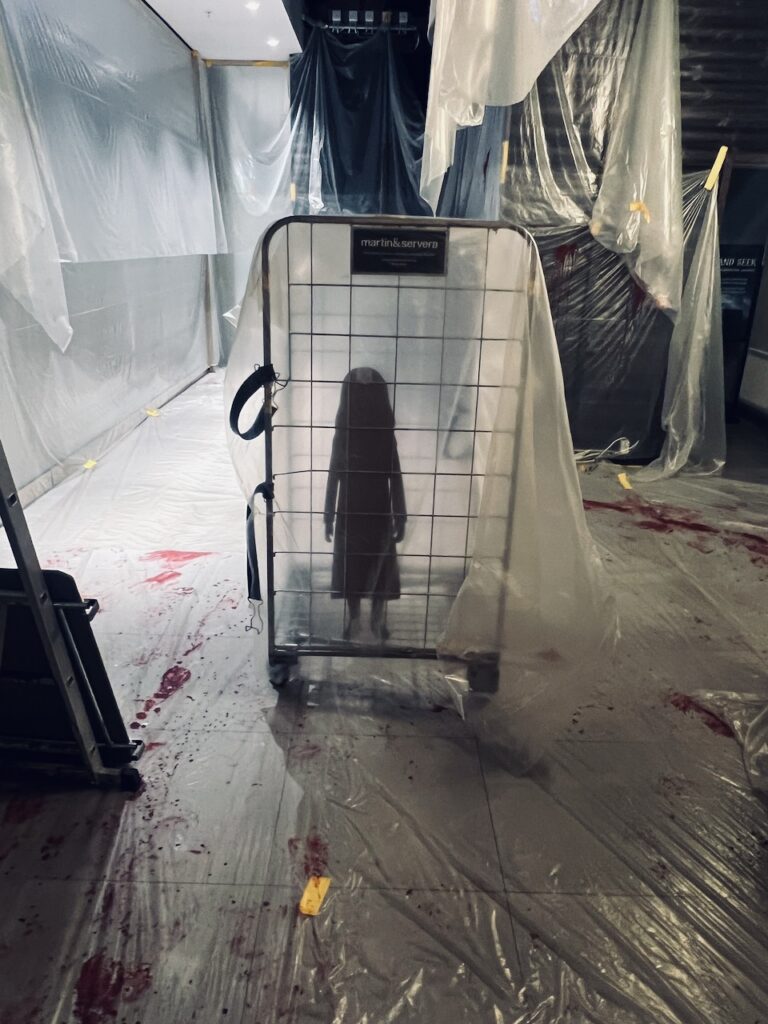 Stämningsfull ljussättning och scenografiska detaljer skapade av TSOI för mystisk spelmiljö i galleria.