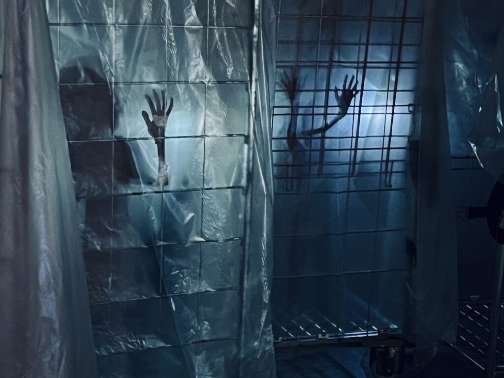 Deltagare gömmer sig i mörklagd galleria under Hide and Seek-eventet med scenografi och rekvisita av TSOI.